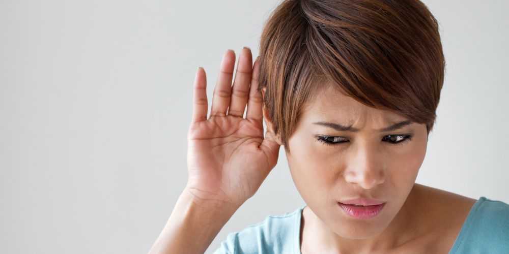 ragazza con i capelli corti e la mano vicino all'orecchio sinistro